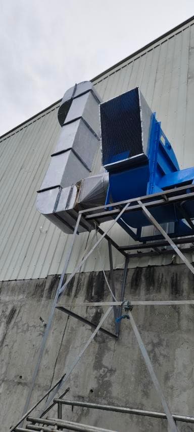 Industrial blue exhaust fan with silver metal ducting mounted on a metal support frame.